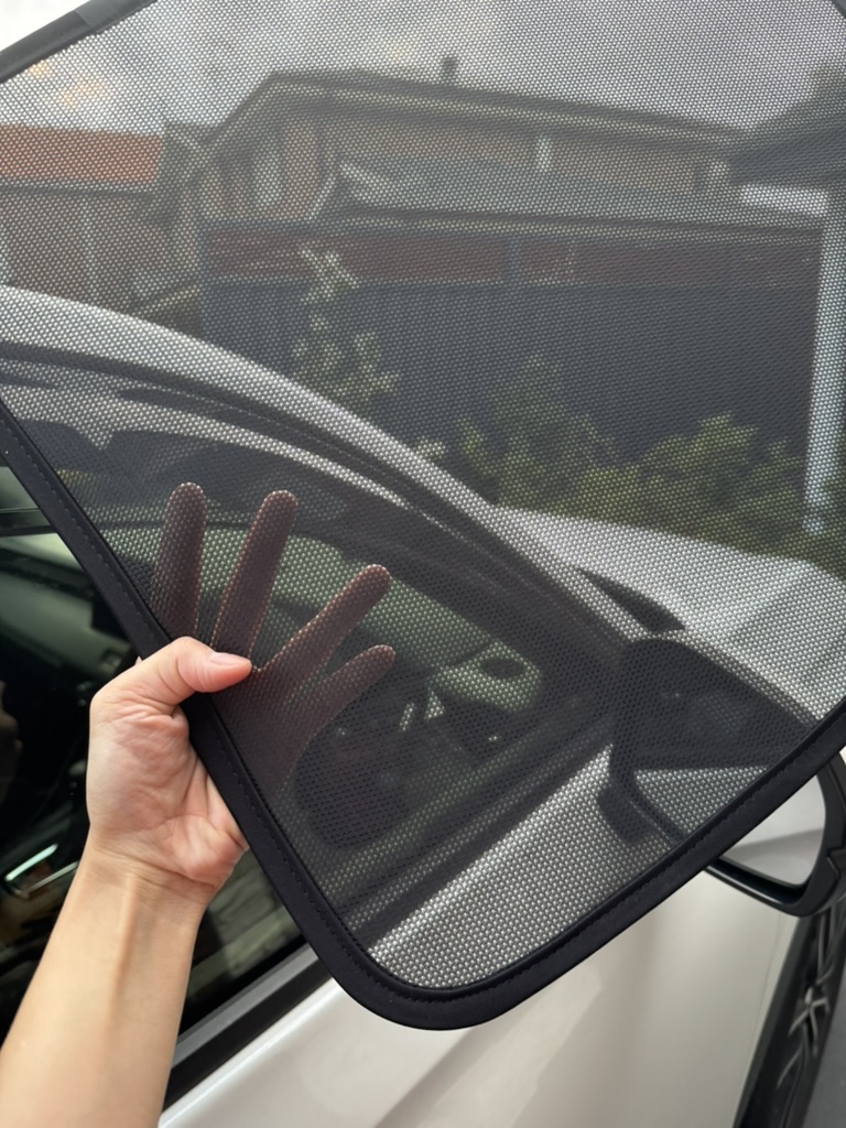 Close-up of magnetic sun shade fitted flush to a car window frame